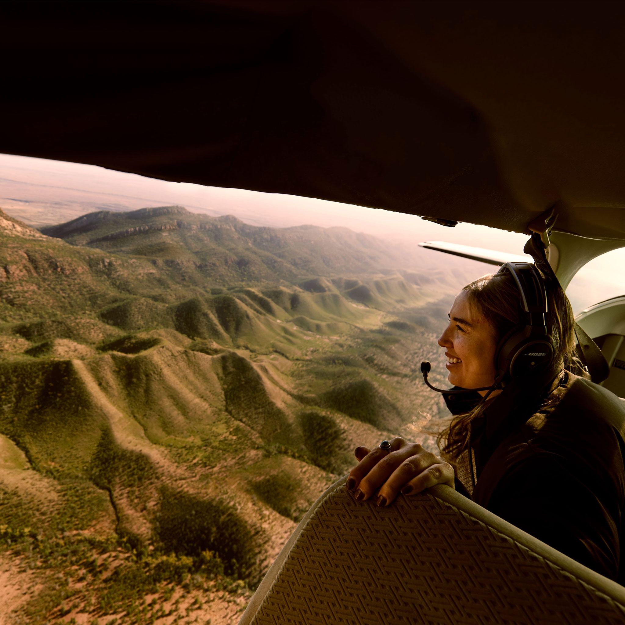 woman gazing out over the Flinders Ranges from the side of a plane