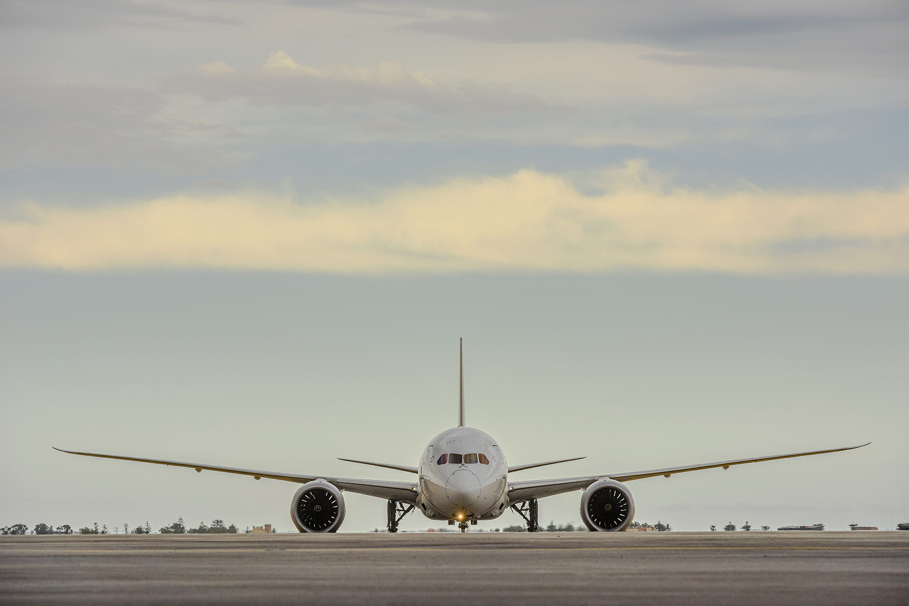 The wing of a plane flying over water and land
