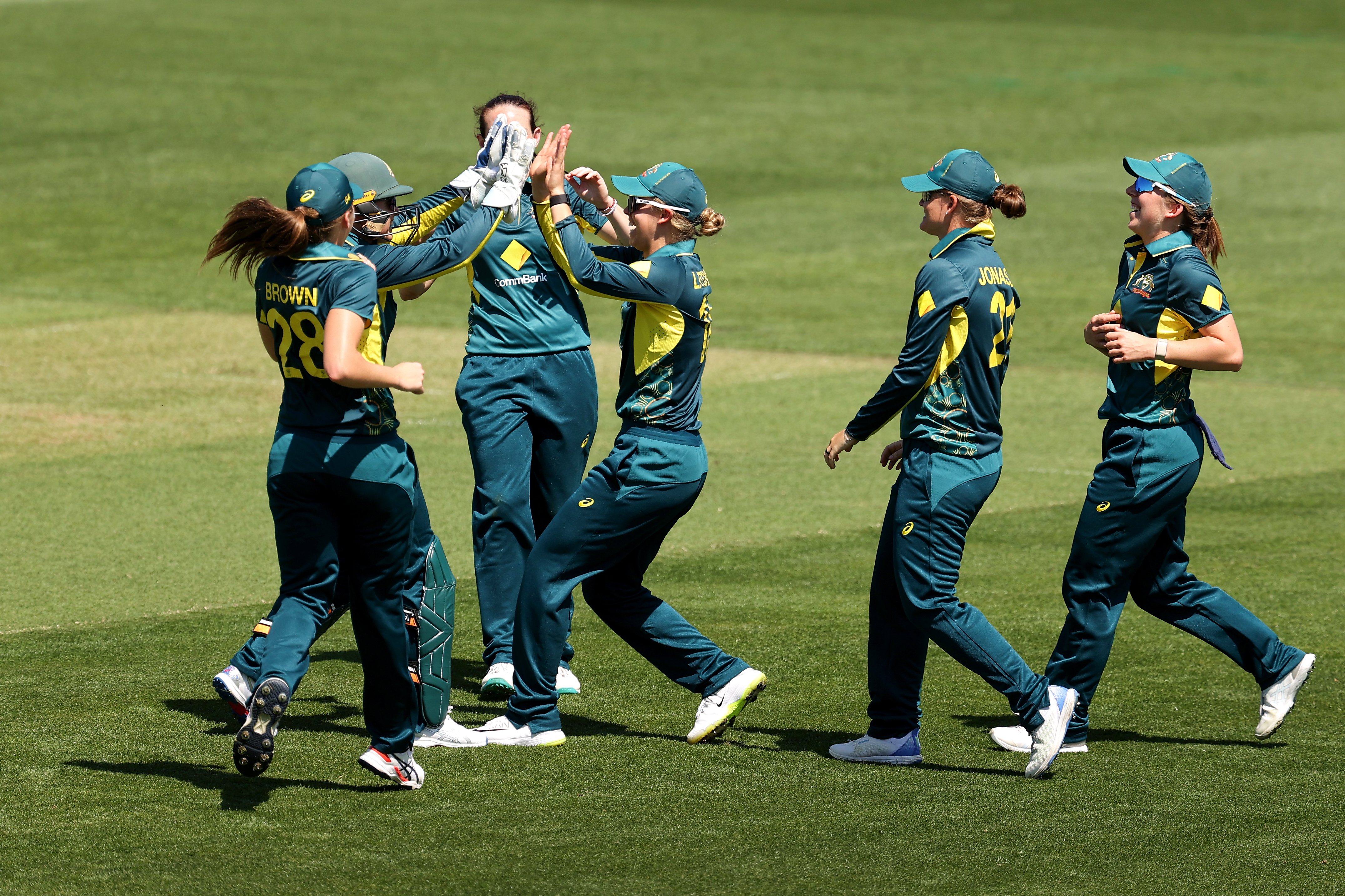 women cricket players celebrating on cricket stadium ground