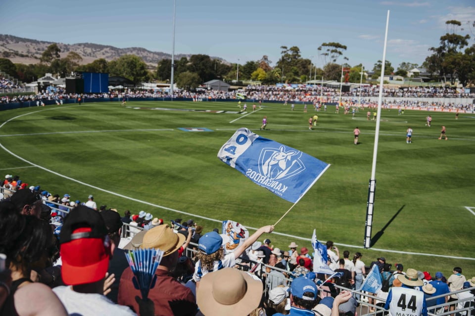 gold coast suns player diving down to grab AFL ball 