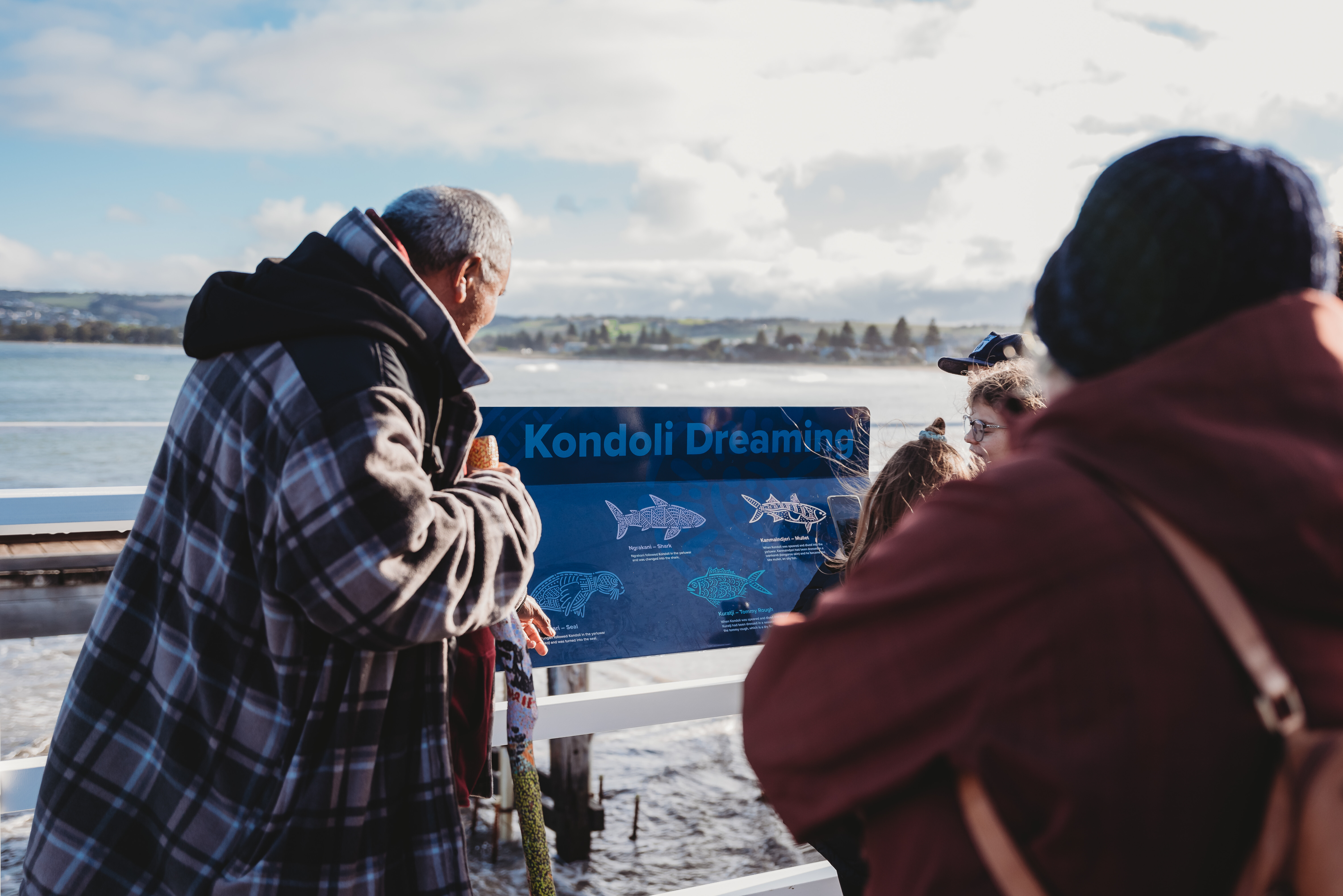 A man guiding visitors through the observation of the whale on Granite Island.