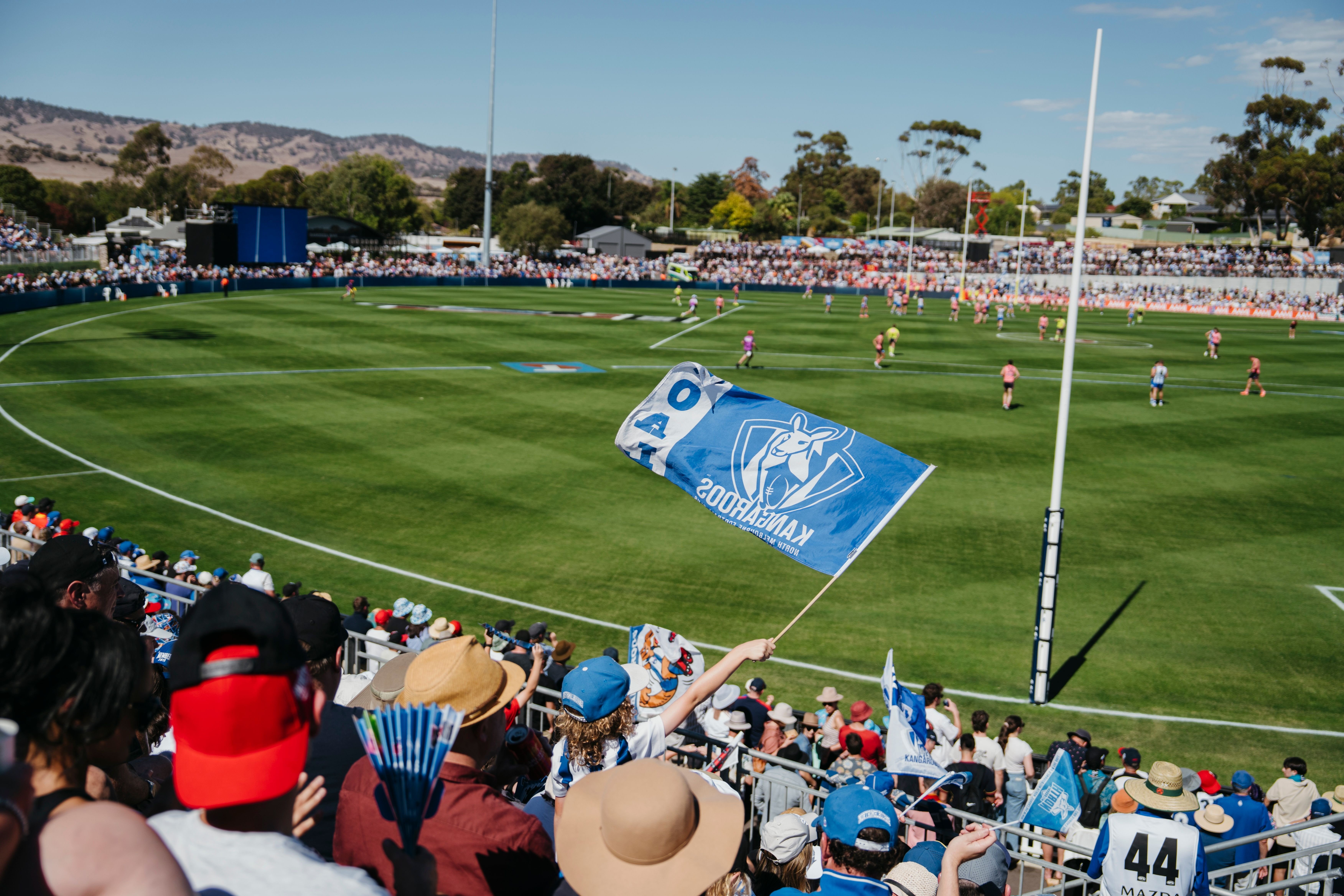 gold coast suns player diving down to grab AFL ball 