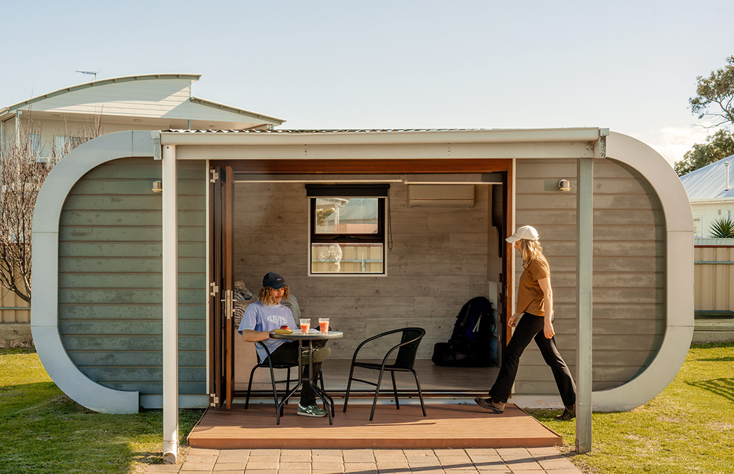 Couple enjoying coffee in front of holiday cabin
