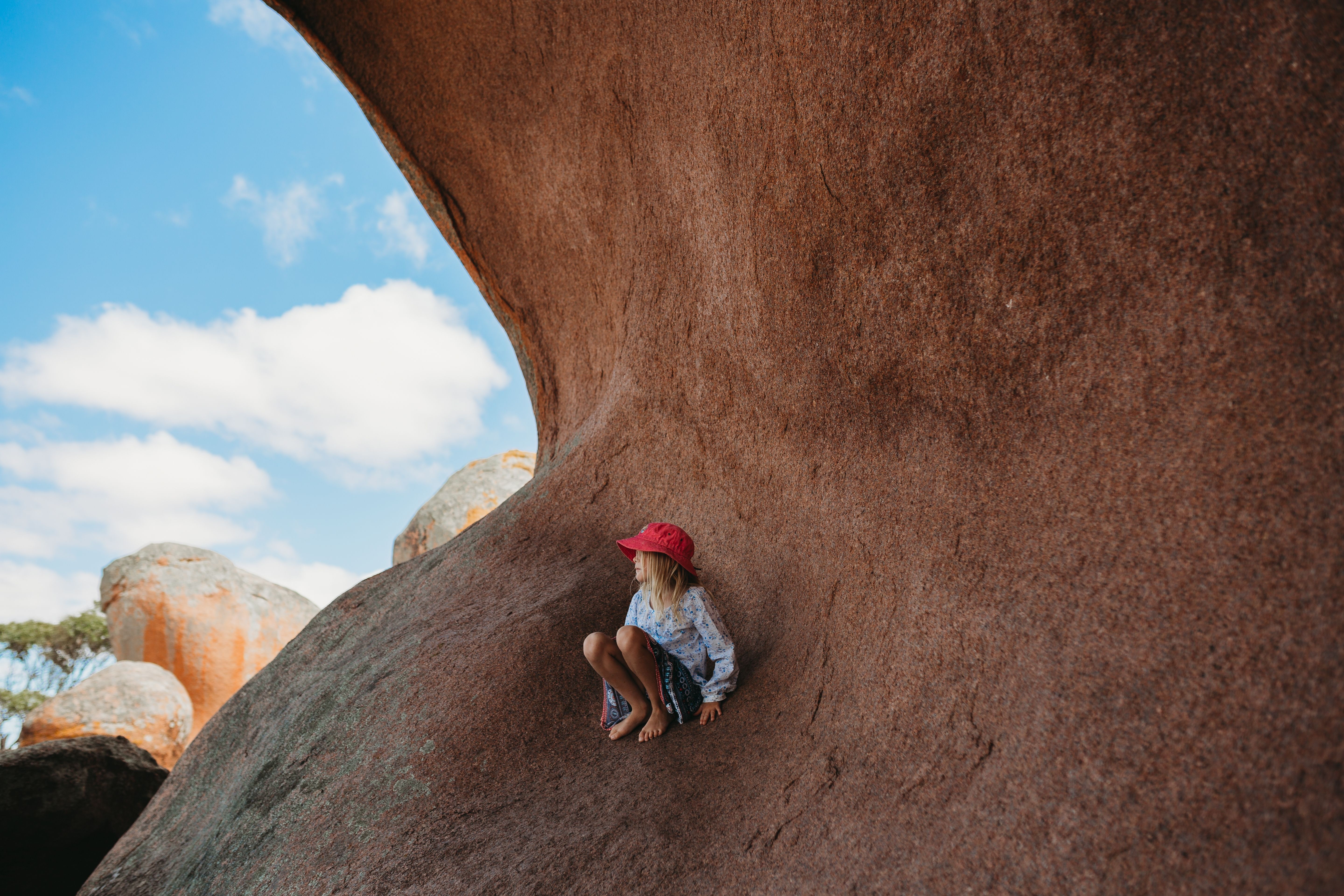 A girl sitting in one of the giant Murphy's Haystacks granits on the Eyre Peninsula